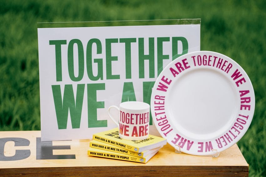 A collection design by Anthony Burrill inspired by his artwork titled Together We Are. The collection features books, wall art, mugs and a plate.