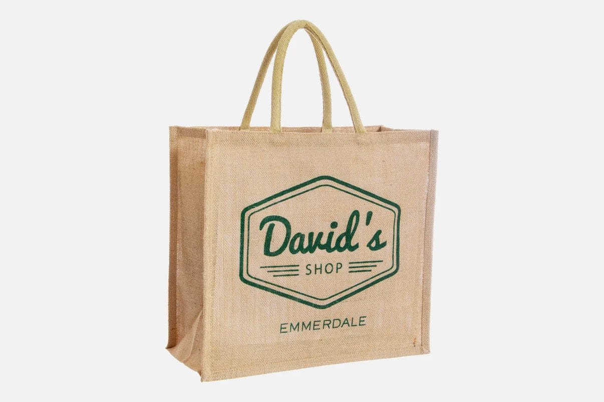A brown square tote bag with David's Shop Emmerdale printed on the front.