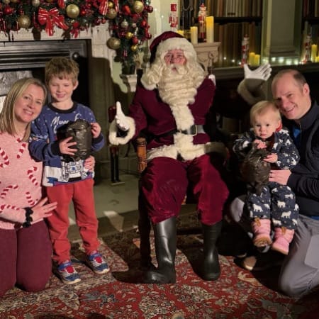 A young family of four enjoy a visit to meet Santa in the Old Library of Harewood House